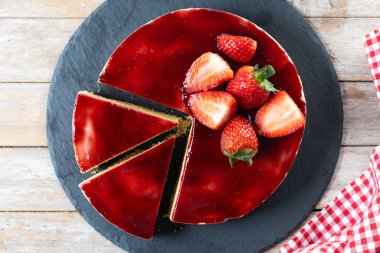 Tahta masada çilekli cheesecake dilimi