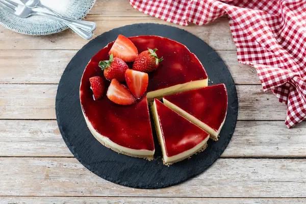 Tahta masada çilekli cheesecake dilimi
