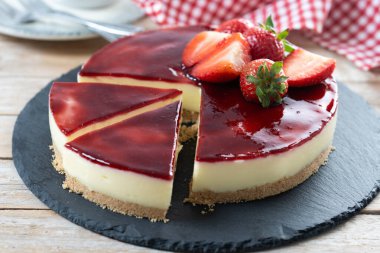 Tahta masada çilekli cheesecake dilimi