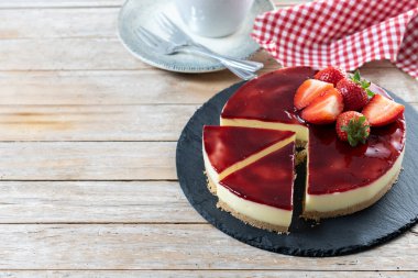 Tahta masada çilekli cheesecake dilimi. Boşluğu kopyala