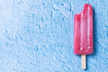 Mavi arka planda kırmızı çilekli dondurma. Üst Manzara. Boşluğu kopyala