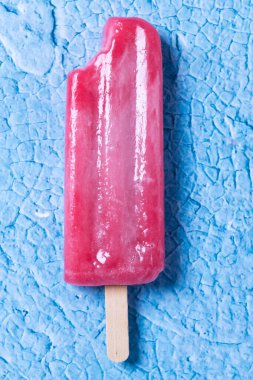 Mavi arka planda kırmızı çilekli dondurmaları ısır. 