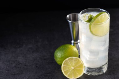 Siyah arka planda limonlu cin kokteyli. Boşluğu kopyala