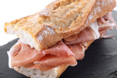 Beyaz arka planda izole edilmiş İspanyol jambonlu sandviçi. İspanyol Bocadillo de Jamon Serrano. Kapat.