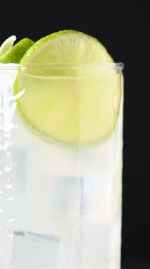 Siyah arkaplanda limonlu cin kokteyli