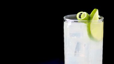 Siyah arkaplanda limonlu cin kokteyli