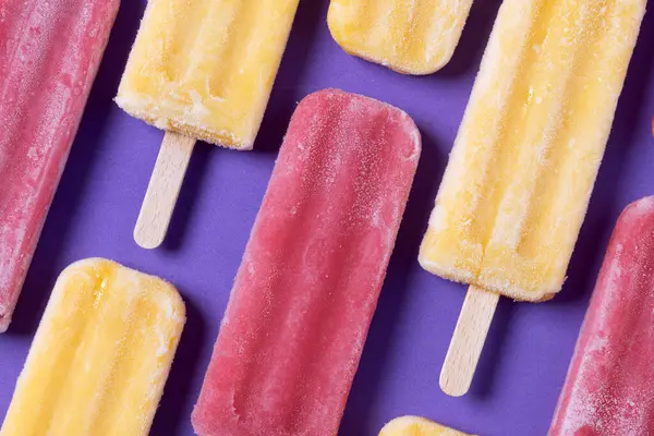 Kırmızı çilekli dondurma ve mor arkaplanda sarı buzlu şeker deseni.