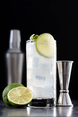 Siyah arka planda limonlu cin kokteyli.