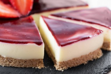 Tahta masada çilekli cheesecake. Kapat.