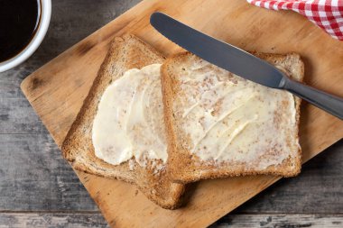Tahta masada taze ekmek ve tereyağı dilimlenmiş.