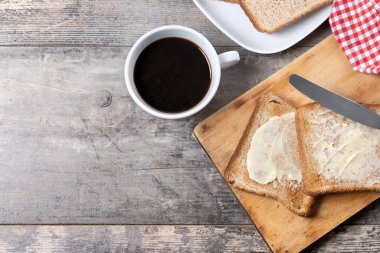 Tahta masada taze ekmek ve tereyağı dilimlenmiş. Üst Manzara. Boşluğu kopyala
