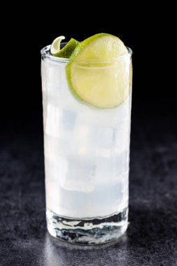 Siyah arka planda limonlu cin kokteyli.