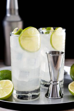 Siyah arka planda limonlu cin kokteyli.