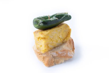 Beyaz arka planda yeşil biber ve omletli İspanyol pinçosu.