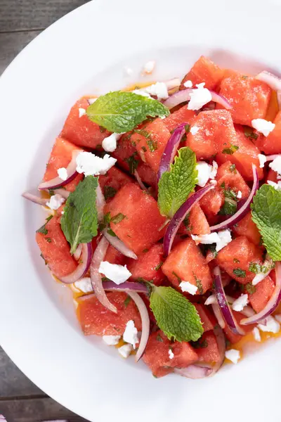 Taze karpuz Feta Salatası Nane ve Kırmızı soğanlı ahşap masa