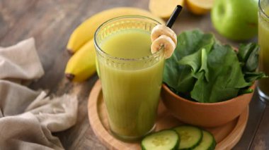 El, Masadan Yeşil Meyve Smoothie alıyor.
