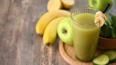 El, Masadan Yeşil Meyve Smoothie alıyor.