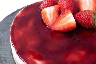 Beyaz arka planda izole edilmiş çilekli cheesecake. Kapat.