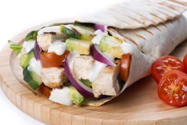 Yumuşak tavuk göğsü, taze sebzeler ve yumuşak tortilla ile sarılmış kremalı sosla dolu lezzetli bir ızgara tavuk dürümü. Beyaz arka planda izole edilmiş hızlı bir öğle yemeği için mükemmel.