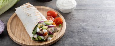 Ahşap masada nefis ızgara tavuk dürümü. Panorama manzaralı. Boşluğu kopyala