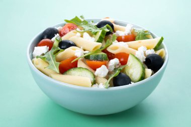 Akdeniz Makarna Salatası kasede Taze sebzeler ve yeşil arka planda bitkiler