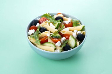 Akdeniz Makarna Salatası kasede Taze sebzeler ve yeşil arka planda bitkiler