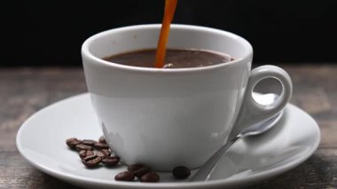 Tahta masada sıcak bir fincana kahve döküyorum.