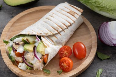 Ahşap masada nefis ızgara tavuk dürümü.