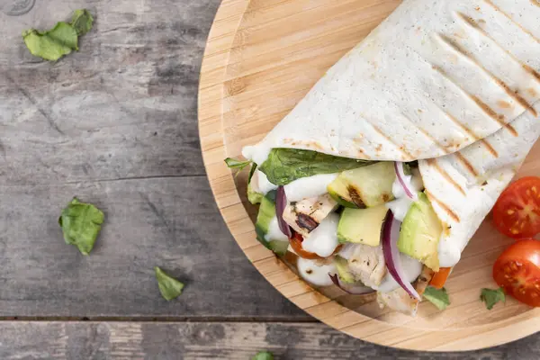 Ahşap masada nefis ızgara tavuk dürümü. Üst Manzara. Boşluğu kopyala