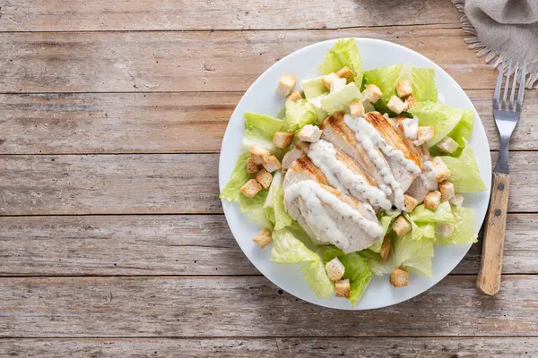 Tahta masada tavuklu çıtır Sezar salatası. Üst Manzara. Boşluğu kopyala