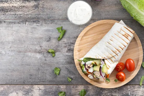 Ahşap masada nefis ızgara tavuk dürümü. Üst Manzara. Boşluğu kopyala