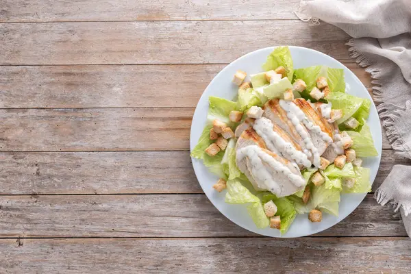 Tahta masada tavuklu çıtır Sezar salatası. Üst Manzara. Boşluğu kopyala