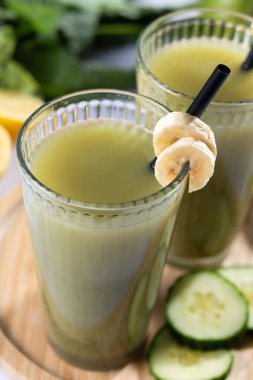 Beyaz mermer üzerinde ıspanaklı, muzlu, elmalı ve limonlu yeşil smoothie.