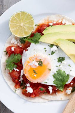 Huevos Rancheros ahşap masada. Geleneksel Meksika kahvaltısı