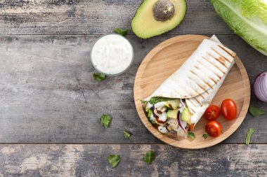 Ahşap masada nefis ızgara tavuk dürümü. Üst Manzara. Boşluğu kopyala