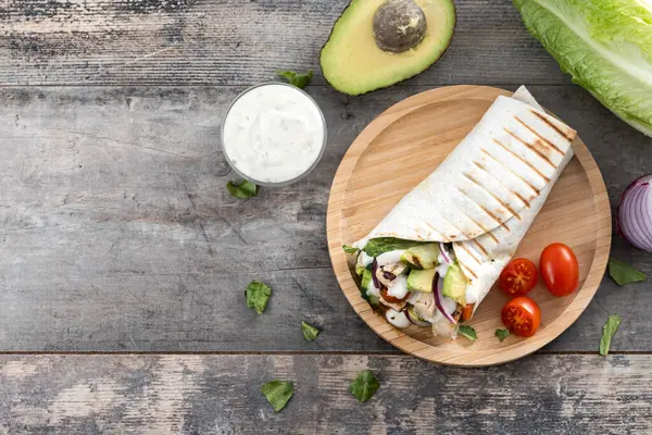 Ahşap masada nefis ızgara tavuk dürümü. Üst Manzara. Boşluğu kopyala