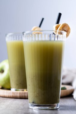 Tahta masada ıspanaklı, muzlu, elmalı ve limonlu yeşil smoothie.