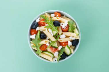 Akdeniz Makarna Salatası kasede Taze sebzeler ve yeşil arka planda bitkiler