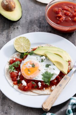 Huevos Rancheros ahşap masada. Geleneksel Meksika kahvaltısı
