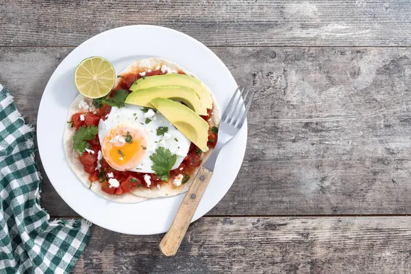 Huevos Rancheros ahşap masada. Geleneksel Meksika kahvaltısı. Üst Manzara. Boşluğu kopyala