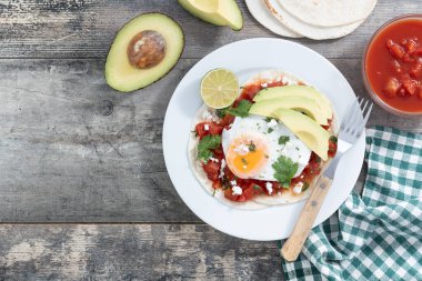 Huevos Rancheros. Geleneksel Meksika kahvaltısı ahşap masada. Üst Manzara. Boşluğu kopyala
