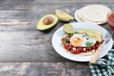 Huevos Rancheros. Geleneksel Meksika kahvaltısı ahşap masada. Boşluğu kopyala
