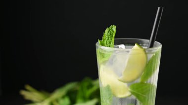 Siyah arkaplanda çilekli cin tonik kokteyli dönüyor