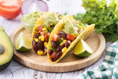 Fasulyeli Meksika Taco 'su ve ahşap masada guacamole.
