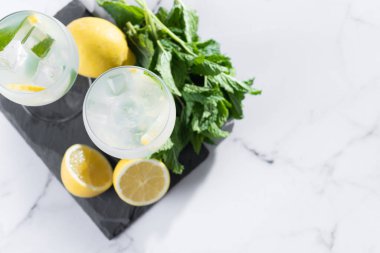 Hugo Cocktail, Lemon, Mint ve Ice in a Wine Glass ile mermer arka planda. Üst Manzara. Boşluğu kopyala