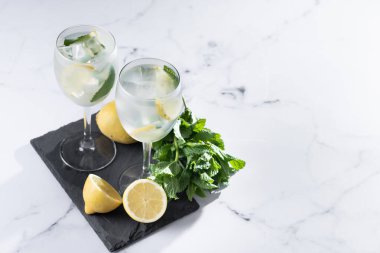 Hugo Cocktail, Lemon, Mint ve Ice in a Wine Glass ile mermer arka planda. Boşluğu kopyala