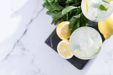 Hugo Cocktail, Lemon, Mint ve Ice in a Wine Glass ile mermer arka planda. Üst Manzara. Boşluğu kopyala