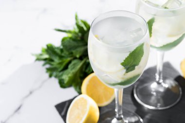 Hugo Cocktail, Lemon, Mint ve Ice in a Wine Glass ile mermer arka planda. Boşluğu kopyala