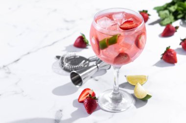 Beyaz mermer arka planda çilekli cin tonik kokteyli. Boşluğu kopyala
