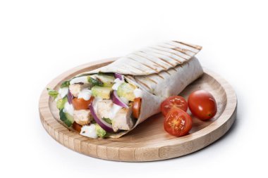 Beyaz arka planda, sebzeli ve avokadolu nefis bir ızgara tavuk dürümü.